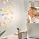 charming female worker sitting front wall with sticky notes pondering best solution office